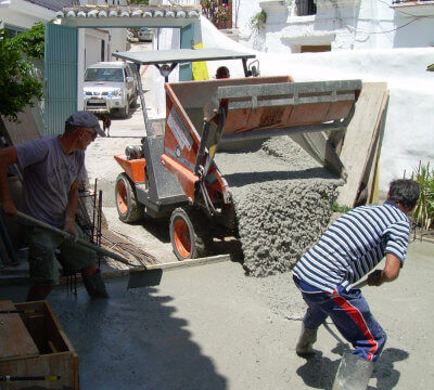 photo of two workers smoothing the freshly poured concrete on a small construction site in Sedella at the Costa del Sol